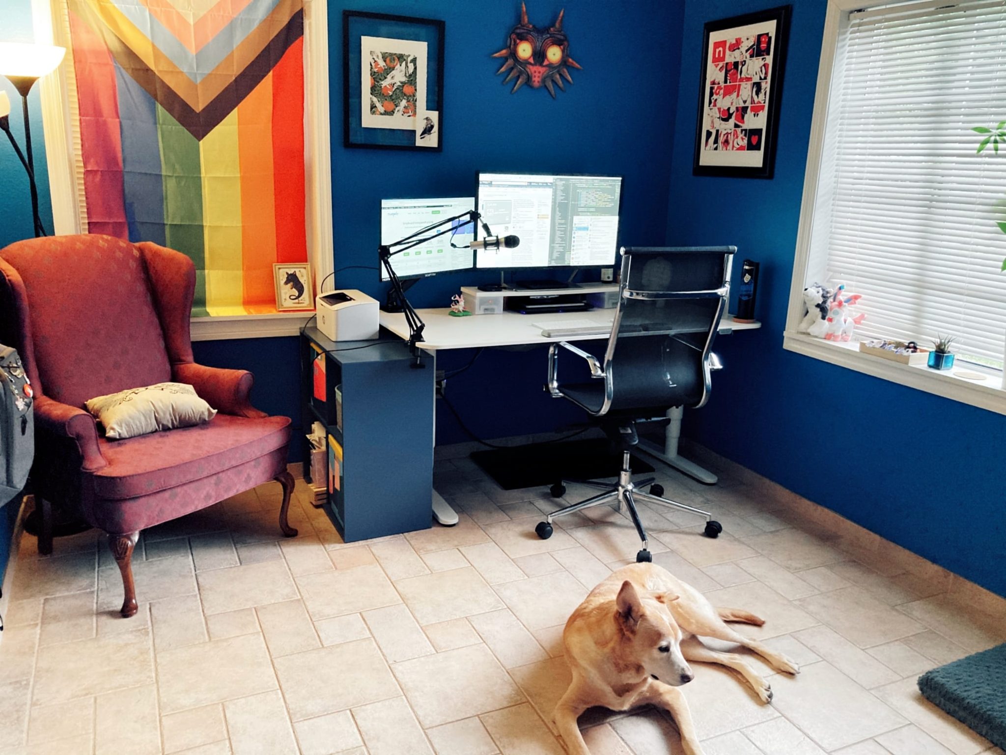 Home office with dark blue walls and a height-adjustable standing desk
