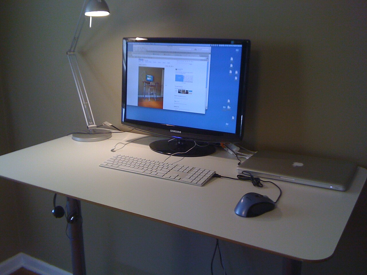 Minimalist standing desk with monitor, keyboard and laptop