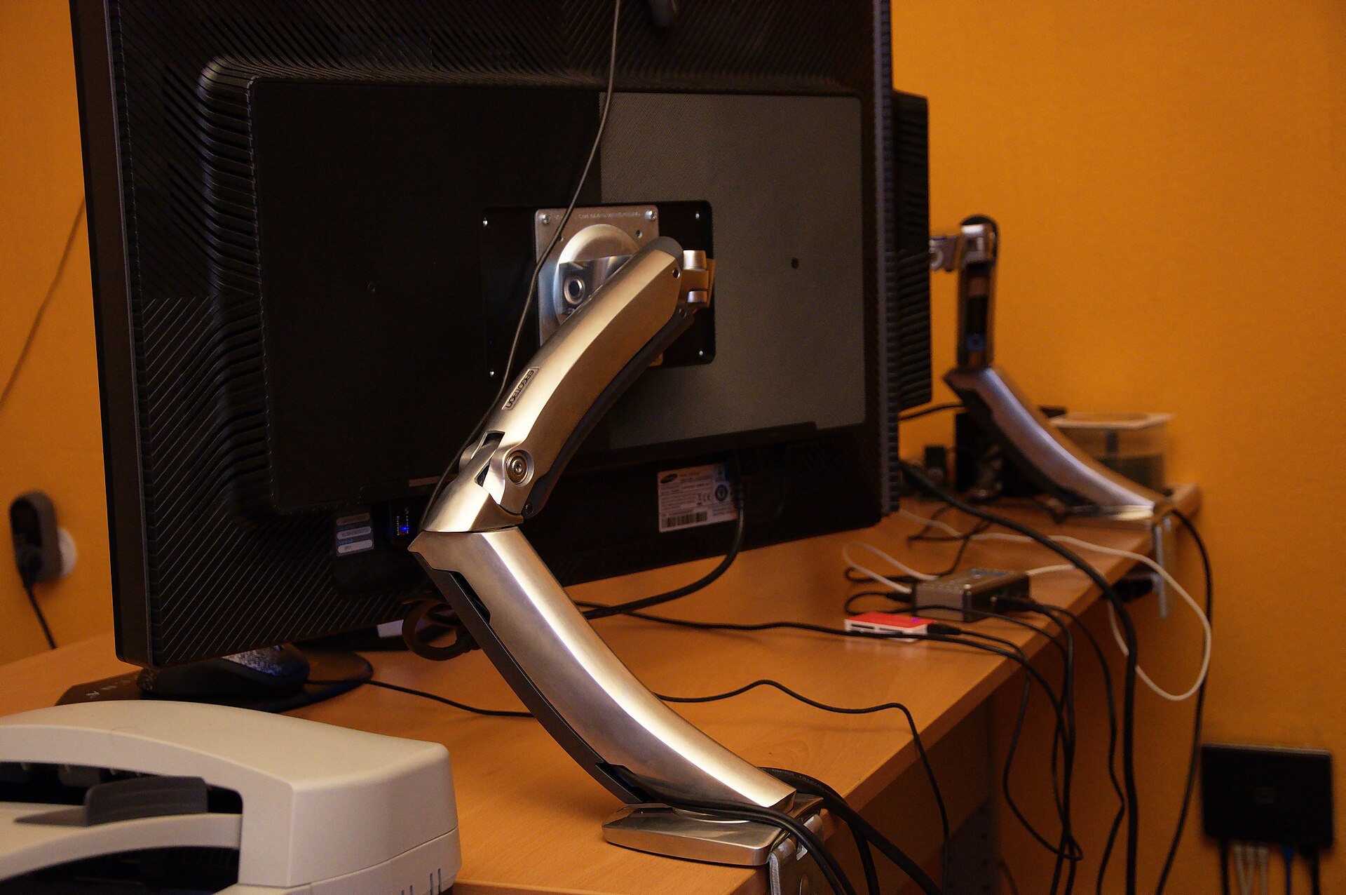 27-inch monitor mounted on a gas-spring monitor arm above a tidy home office desk