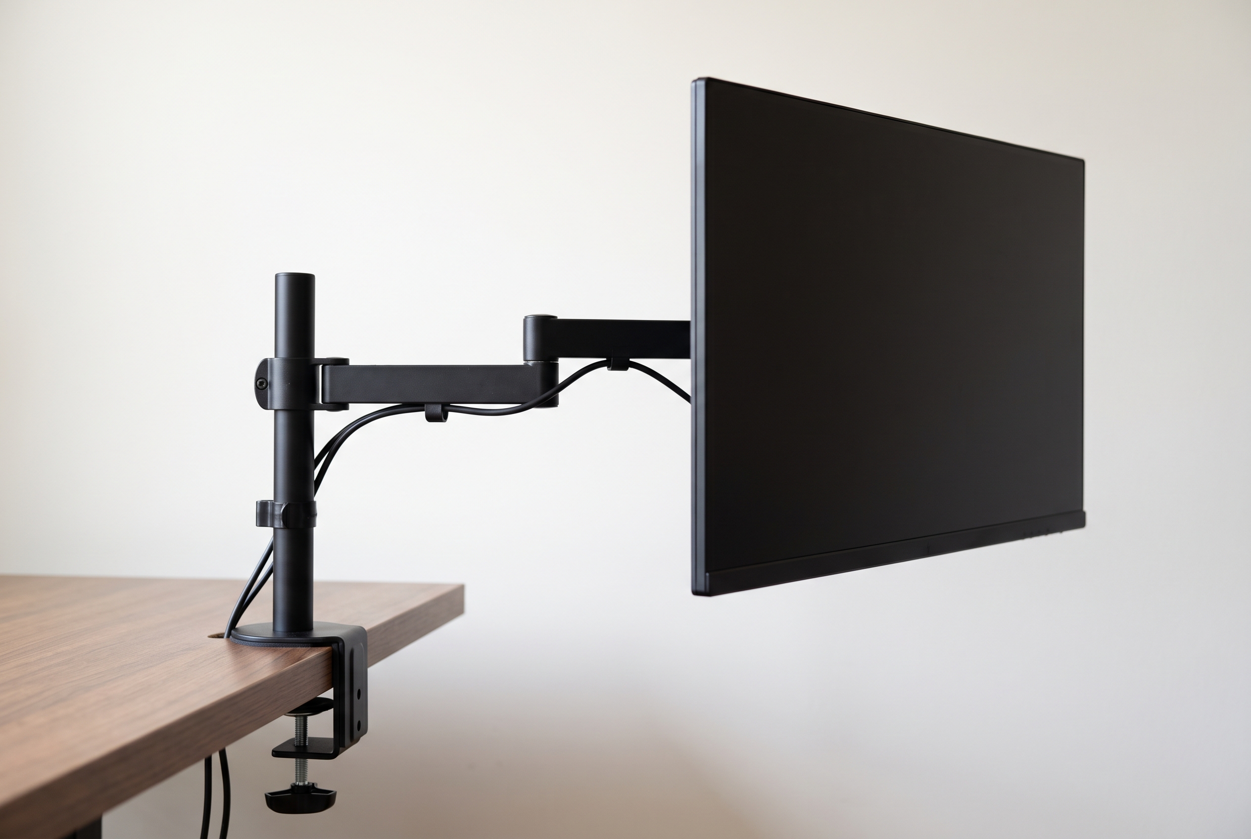 Budget monitor arm clamped to a desk edge