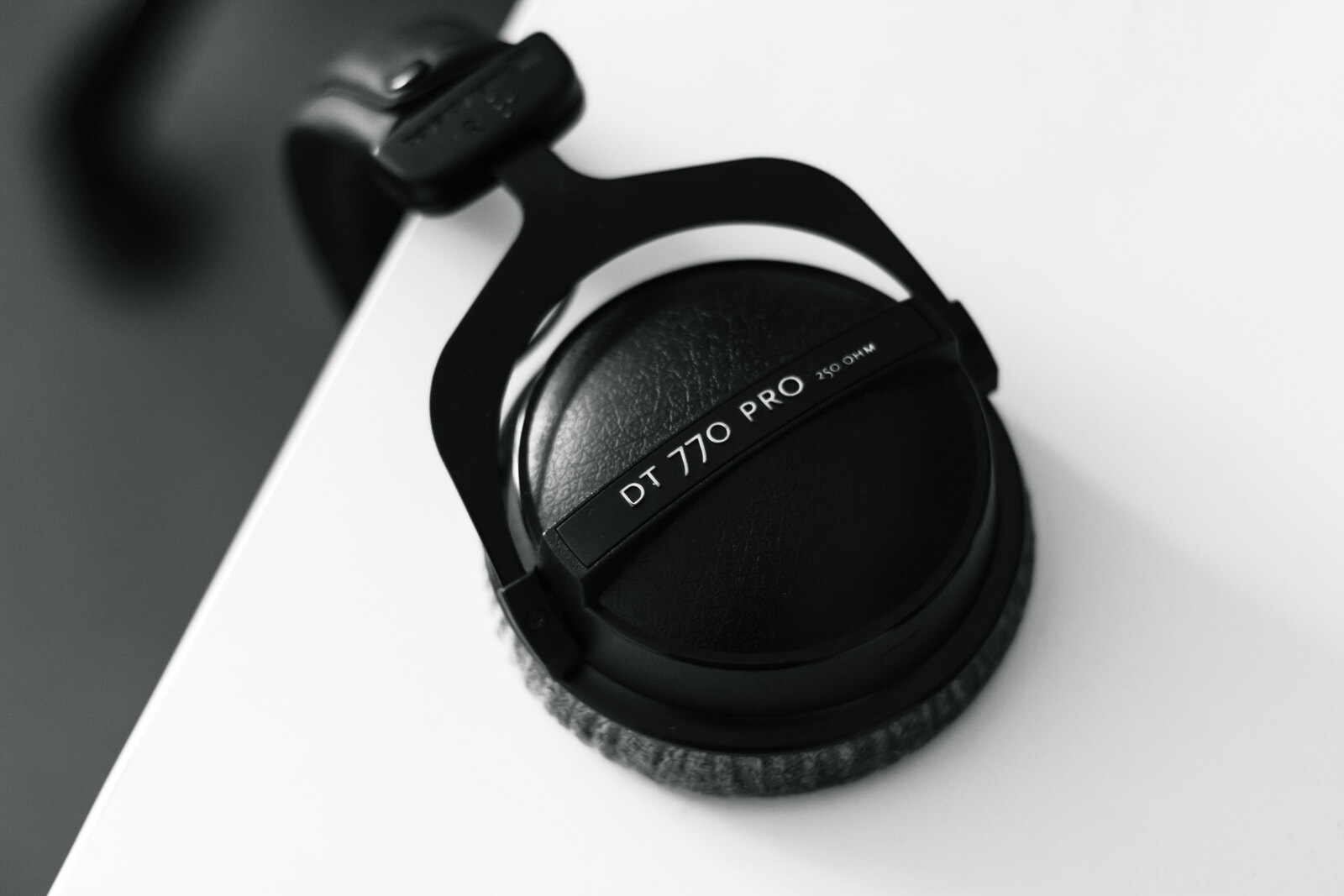 Over-ear headphones and a keyboard on a home office desk, viewed from above
