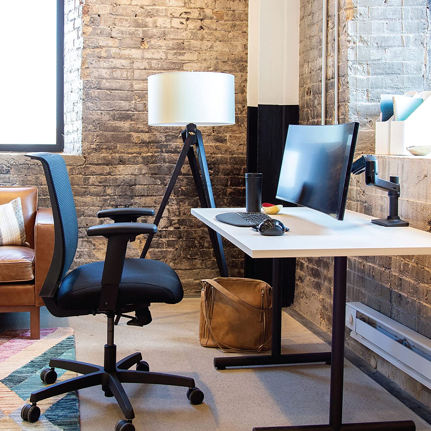 Black monitor arm holding a 32-inch screen above a tidy desk workspace