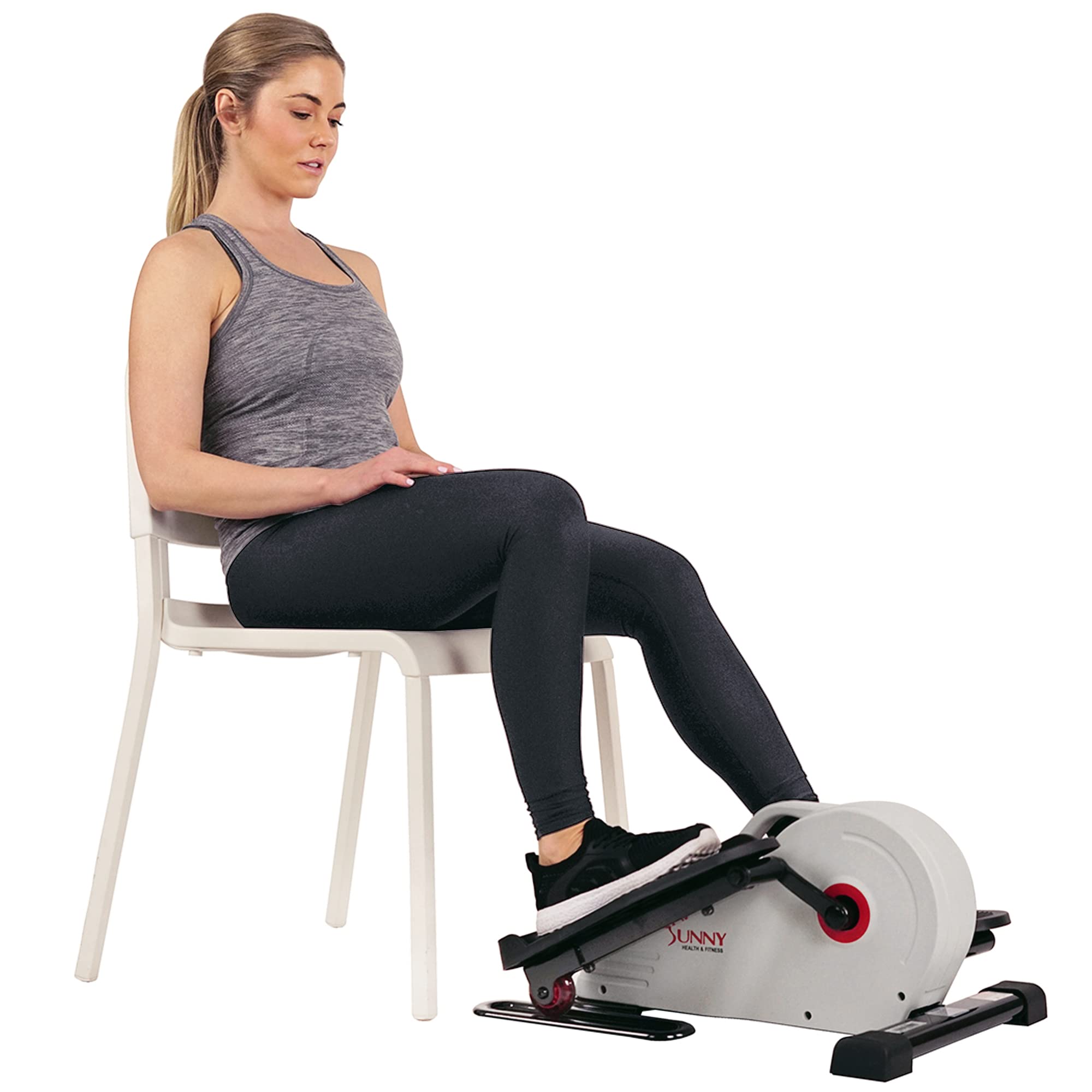 Woman seated on a chair using a Sunny Health and Fitness under-desk pedal exerciser